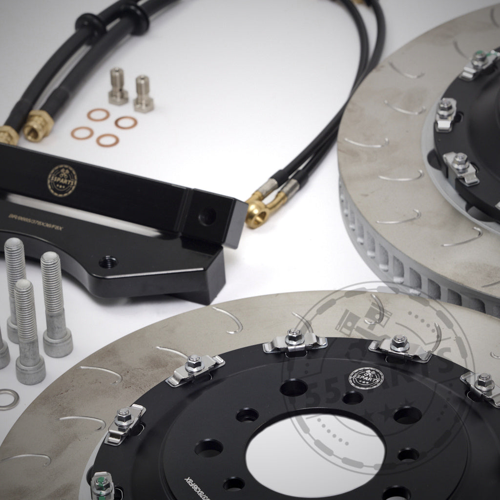 Nahaufnahme des 55Parts-Specials: Komponenten des AP Racing Pro 5000 R CP9665 Big Brake Kit, einschließlich Rotoren, Schrauben, Schläuchen und Halterungen auf weißem Hintergrund. Perfekt für Rennstreckenfans, die Präzision und Zuverlässigkeit suchen.