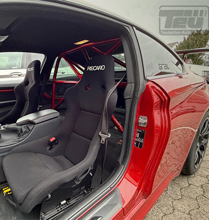 Roter BMW F82 M4 mit offener Tür, ausgestattet mit einem schwarzen Recaro-Rennsitz und einem 55Parts Teutscher Clubsportbügel (inkl. Materialzertifikat) im Inneren.