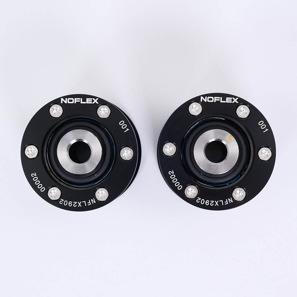 Zwei schwarze kreisförmige NoFlex-Lager von 55Parts mit Bolzen und Zentrierbohrungen, passend für BMW 3er E36, E46, X3 E83, Z4 E85/E86 Querlenker hinten, sind von oben auf einer weißen Fläche abgebildet.
