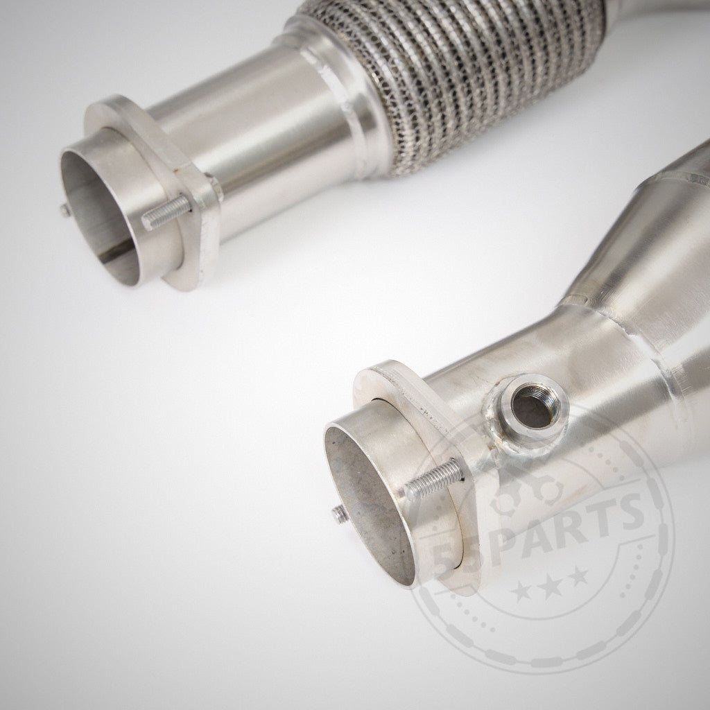 Nahaufnahme von zwei Edelstahl High Flow Downpipes (mit 200 Zeller Euro 6 Katalysatoren), passend für BMW G87 M2, G80 M3, G82 M4 S58 von 55Parts & MH Pipes mit Flanschen und Schweißnähten auf weißem Hintergrund.