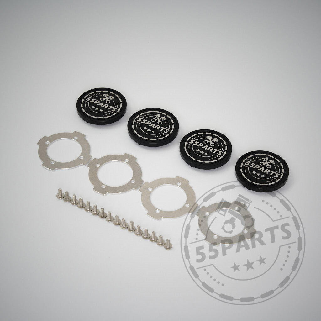 Vier 55Parts CNC-gefräste, verschraubte Radnabendeckel für ProTrack One Felgen, mit vier silbernen Ringen und einer Reihe Metallkugeln, sind auf weißem Grund abgebildet. Die hochwertige Aluminiumkonstruktion unterstreicht dieses stilvolle Zubehör.