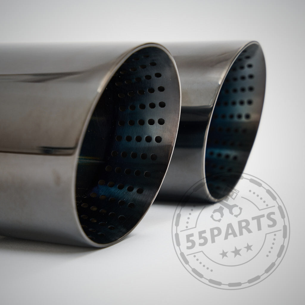 Nahaufnahme von zwei metallischen 3" ECE Equal Length Abgasanlage-Auspuffblenden, entworfen passend für BMW F8x M2 Competition, M3 und M4; perforierte Innenverkleidungen und auffälliges 55Parts-Logo im Vordergrund.