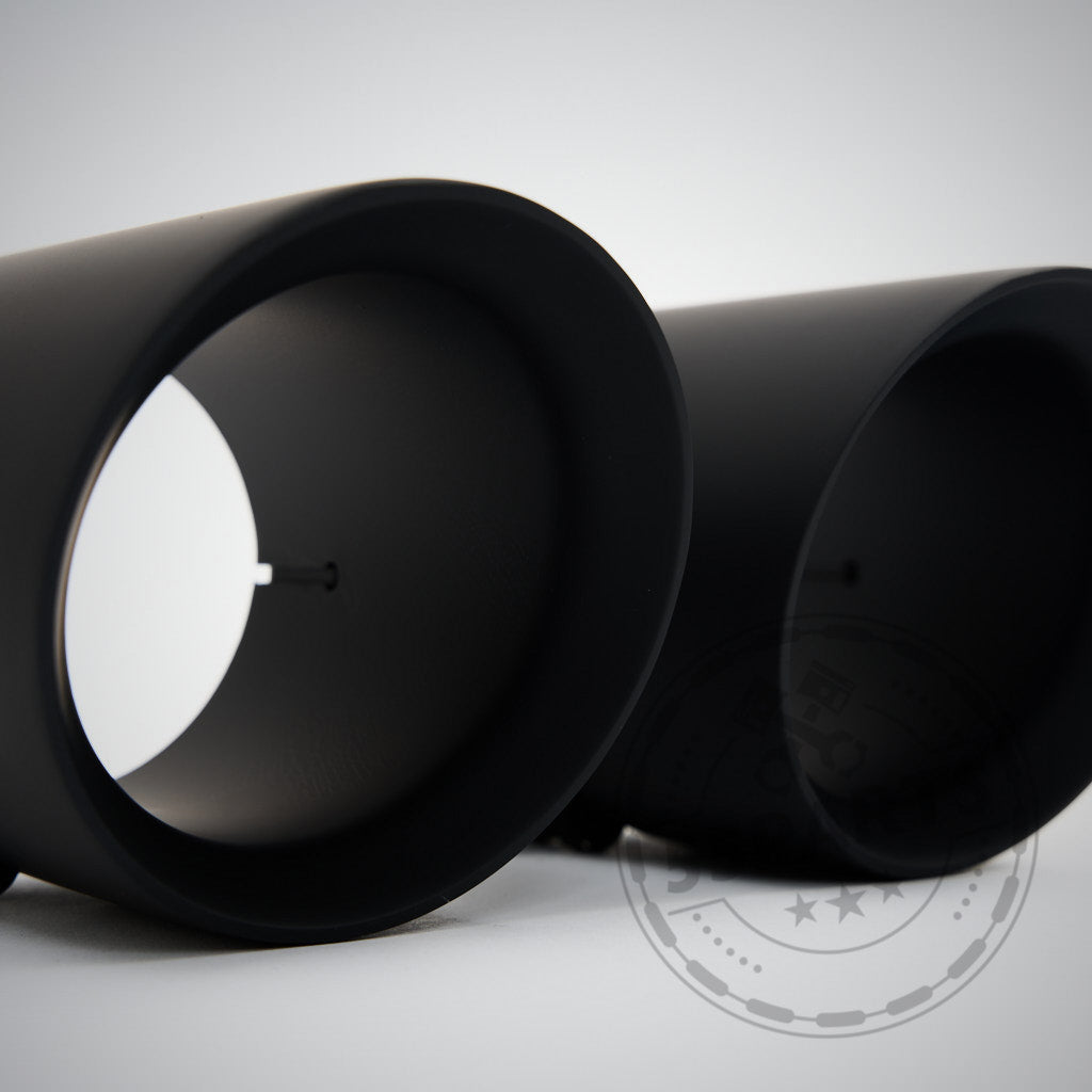 Auf einer weißen Fläche sind zwei schwarze, zylindrische Bauteile der 55Parts &amp; MH-PIPES 3,5" ECE Klappenauspuffanlage für alle B58 BMW Modelle (inkl. Toyota Supra) abgebildet.