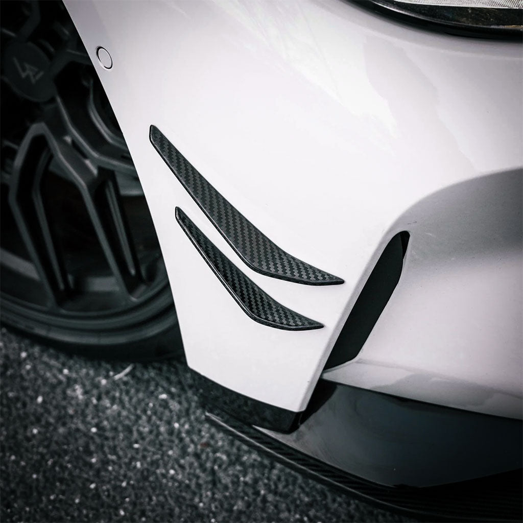 Eine Nahaufnahme der Twistnfix TNF+ Performance Canards Carbon, passend für BMW M3 (G80/G81) &amp; M4 (G82/G83), inkl. Teilegutachten, hebt die schlanken Prepreg-Carbon-Details und die Leistungsstärke hervor.
