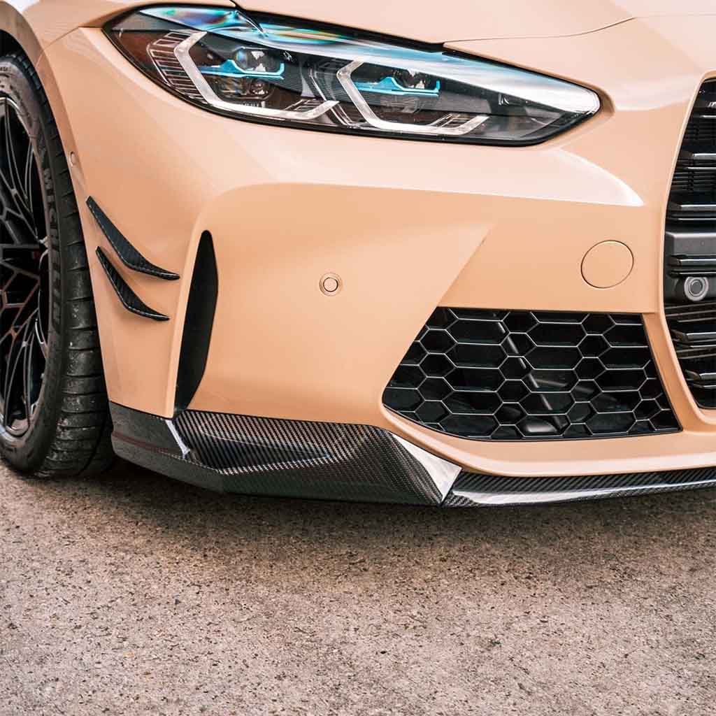 Nahaufnahme der vorderen linken Seite eines beigen Sportwagens mit schwarzen Akzenten, Wabengitter und einem Twistnfix TNF+ Performance Frontspoiler Carbon für BMW M3 (G80/G81) und M4 (G82/G83), inklusive Teilegutachten.