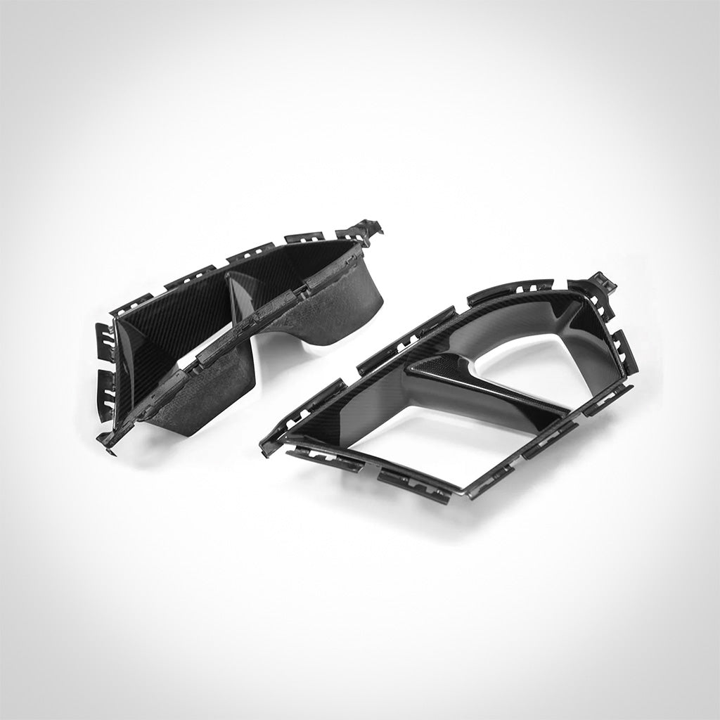 Zwei schwarze, kohlefaserstrukturierte TNF+ Performance Lufteinlässe von Twistnfix für BMW M3 (G80/G81) und M4 (G82/G83), abgebildet auf weißem Hintergrund, beinhalten Teilegutachten.
