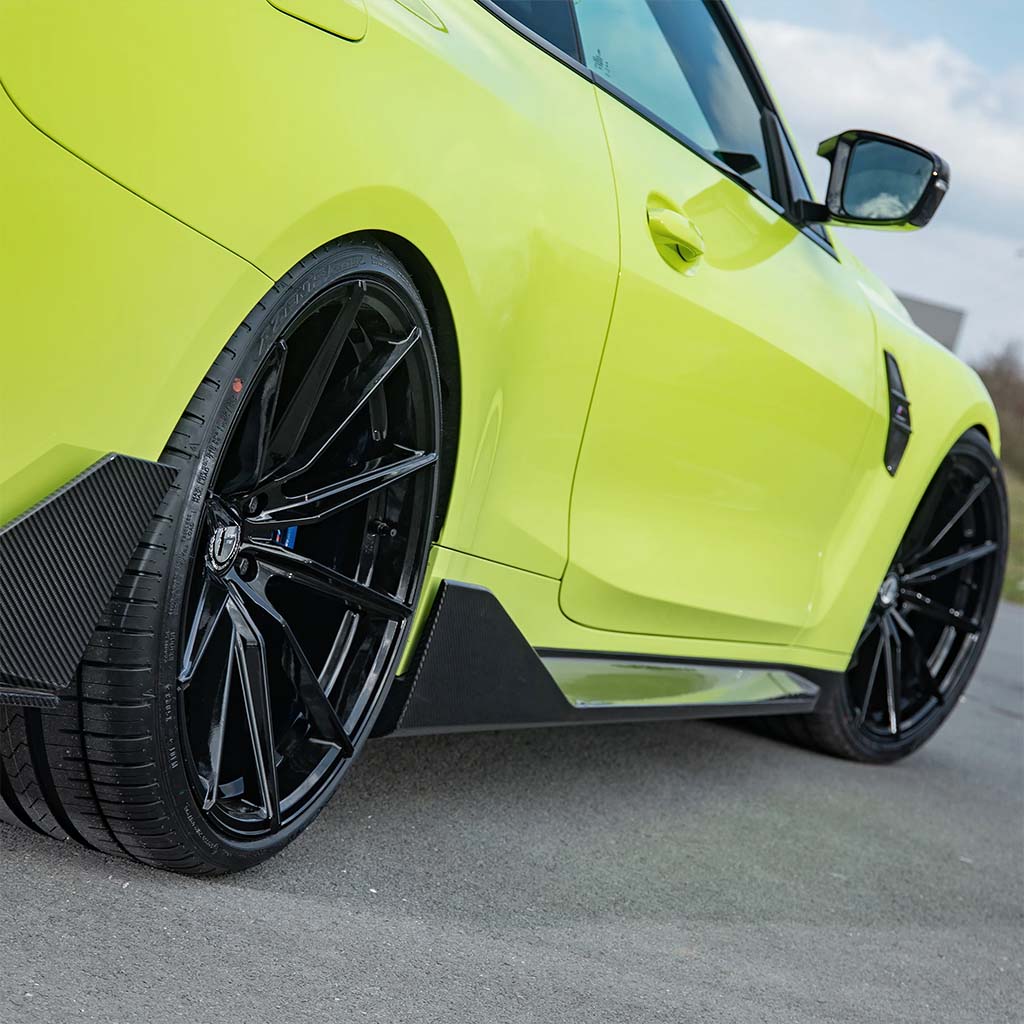 Nahaufnahme eines leuchtend gelben Sportwagens mit schwarzen Felgen, ausgestattet mit Twistnfix TNF+ Performance Seitenschweller Carbon für BMW M3 (G80/G81), inklusive Teilegutachten, für mehr Stil und Leistung.