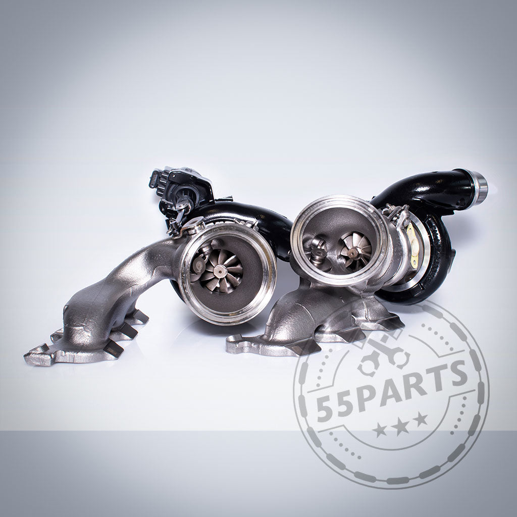 Zwei schwarze Turbosystems Upgrade-Turbolader-Einheiten für die Motoren BMW G87 M2, G80/G81 M3, G82/G83 M4, F97 X3M und F98 X4M S58 auf hellem Hintergrund mit einem 55Parts-Logo-Wasserzeichen in der Ecke.