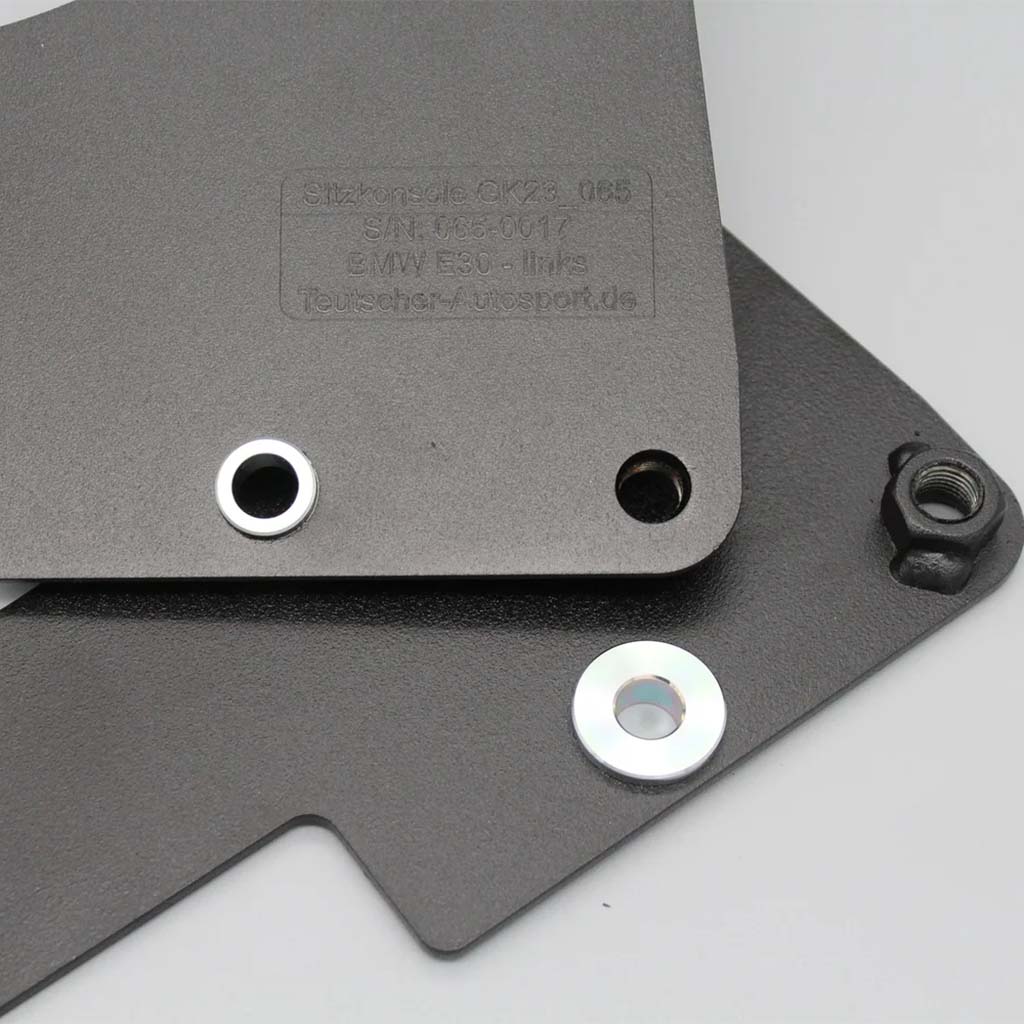 Zwei überlappende schwarze Metallplatten mit Löchern und Unterlegscheiben auf hellgrauem Hintergrund. Teutscher Recaro Pole Position Sitzkonsolen, passend für BMW E30 inkl. Materialnachweis. Materialnachweis.