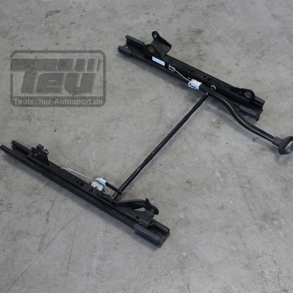 Eine schwarze Metall Teutscher Recaro/Sparco/OMP Sitzkonsole, passend für VW Golf 7, Audi TT, Seat Leon Cupra, inkl. Materialzeugnis und Verstellhebel, abgebildet auf einem grauen Betonboden.