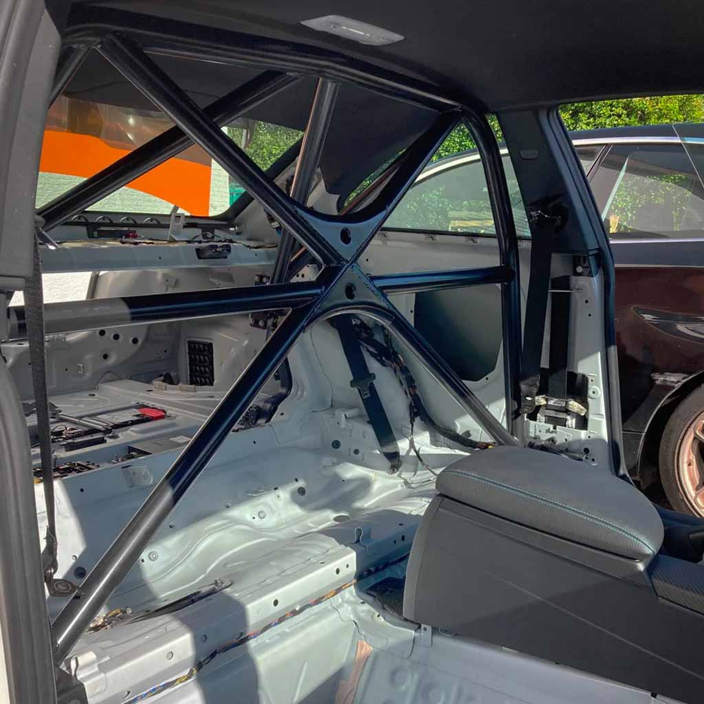 Der Teutscher Clubsportbügel passend für BMW F87 M2 incl. Materialzertifikat verfügt über einen gestrippten Innenraum mit sichtbarem schwarzen Überrollbügel, freiliegenden Metallrahmen, keine Rücksitze und ist individuell für Rennstrecken-Setups konfigurierbar.