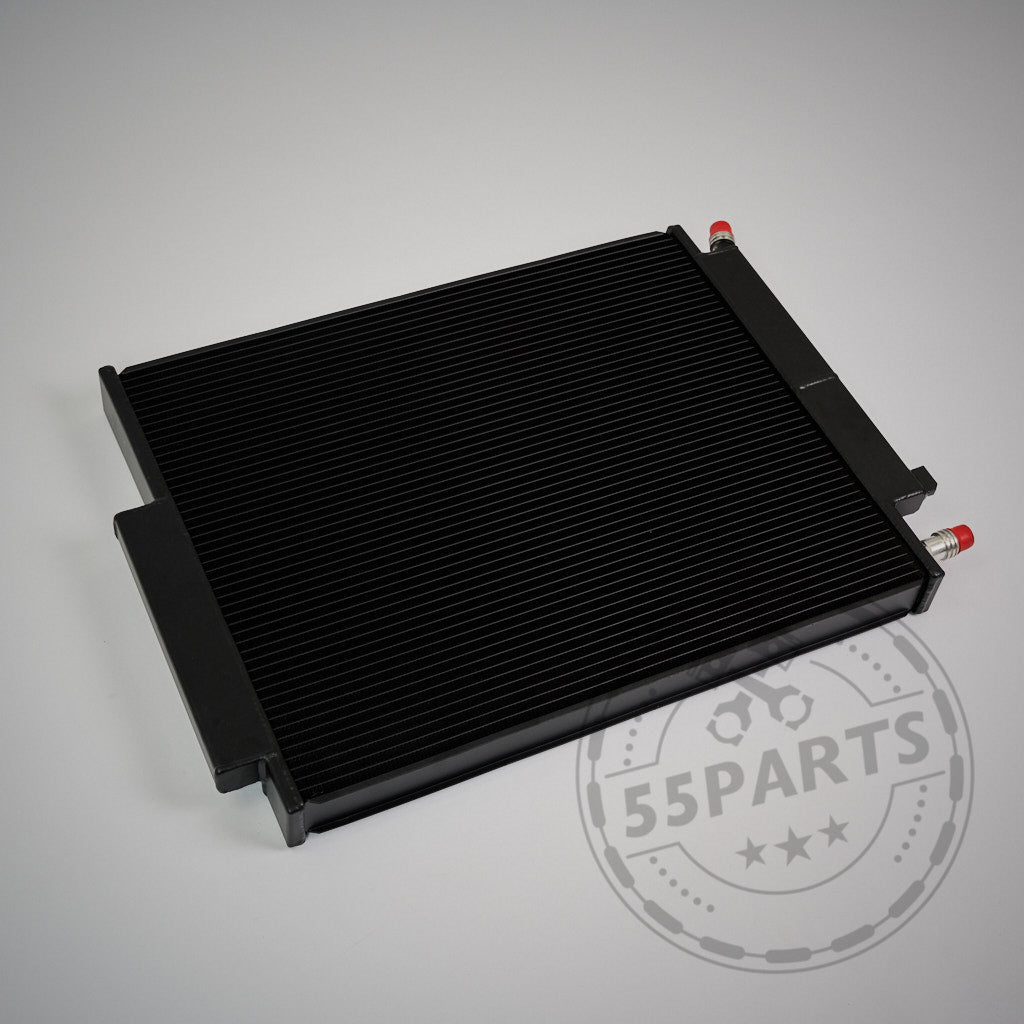 Der 55Parts Upgrade Kühlmittelkühler, passend für BMW G42 M240i & mehr mit B48/B58 Gen 2, in Schwarz mit roten & silbernen Anschlüssen, liegt auf grauer Fläche. Abgebildet: Wasserkühler Ladeluftkreislauf.