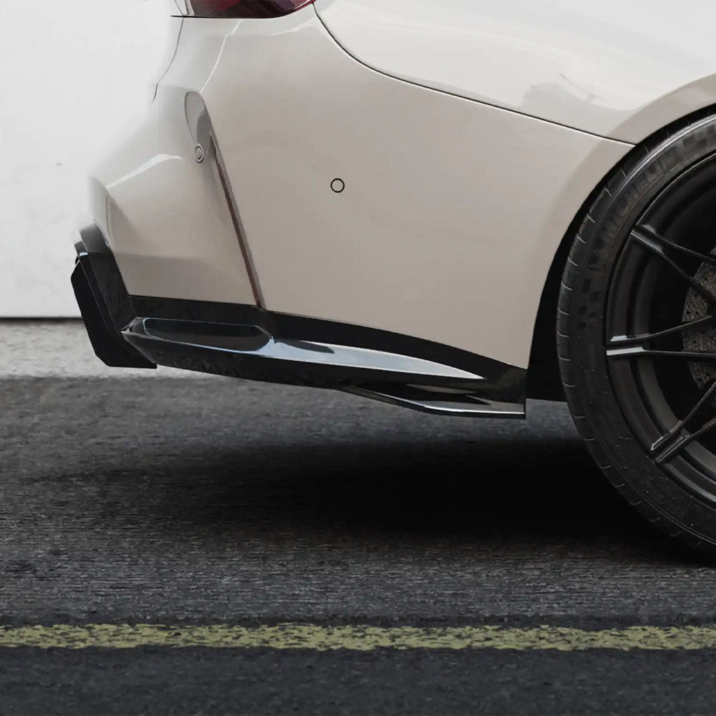 Rückansicht einer beigen BMW-Limousine mit schwarzen Rädern, ausgestattet mit einem ZAERO Design EVO-S Diffusor Erweiterung für BMW M3 G80/G81, geparkt neben einer weißen Wand.