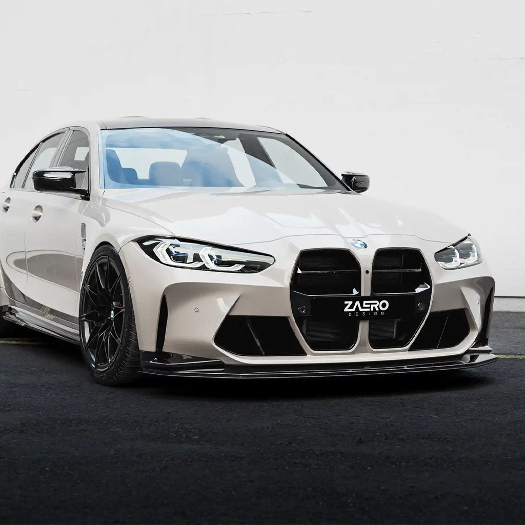 Ein beiger BMW M3 G80 mit schwarzen Felgen und einem sportlichen ZAERO Design EVO-S Frontgrill ist auf einer schwarzen Straße geparkt, von vorne links gesehen.