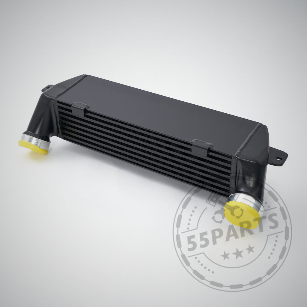 Schwarzer Upgrade-Ladeluftkühler passend für BMW 325d, 330d, 335d M57, mit gelben Kappen auf hellem Hintergrund und dem 55Parts-Wasserzeichen.
