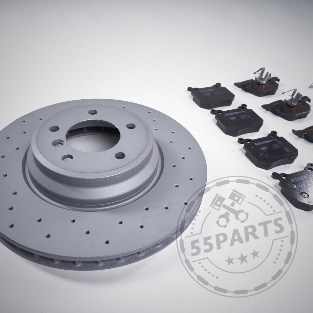 Das 55Parts-Special: Bremsen (Upgrade) Set Hinterachse passend für BMW 3er E9x 335i mit grauen belüfteten und gelochten Bremsscheiben sowie schwarzen Belägen und Hardware wird auf hellem Hintergrund angezeigt.