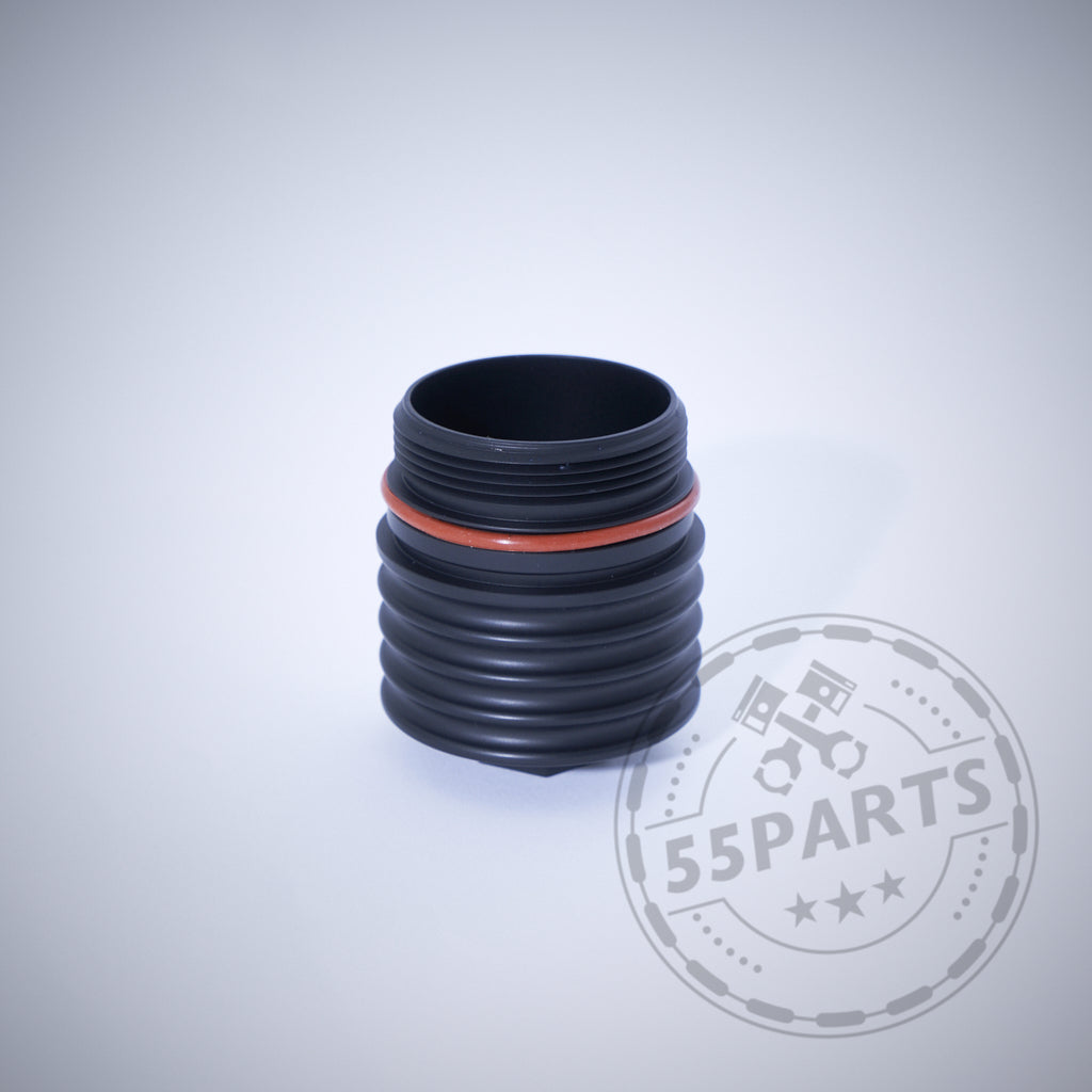 Schwarzes gewelltes zylindrisches Autoteil mit orangefarbenem Ring auf hellem Hintergrund. Features 55Parts Exclusive: Aluminium-Ölfilterkappe mit Sechskant, passend für BMW N20, N57, N52, N53, N54, N55, S55, B46, B48, B57 &amp; B58. Wasserzeichen vorhanden.