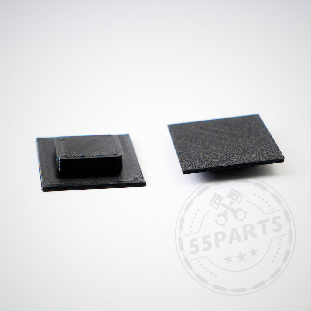 Zwei schwarze Kunststoff-3D-Druck-Einsätze für Stoßstange mit kurzem Kennzeichen passend für Toyota Yaris GR von werden auf weißem Hintergrund gezeigt, einer davon ist mittig erhöht.