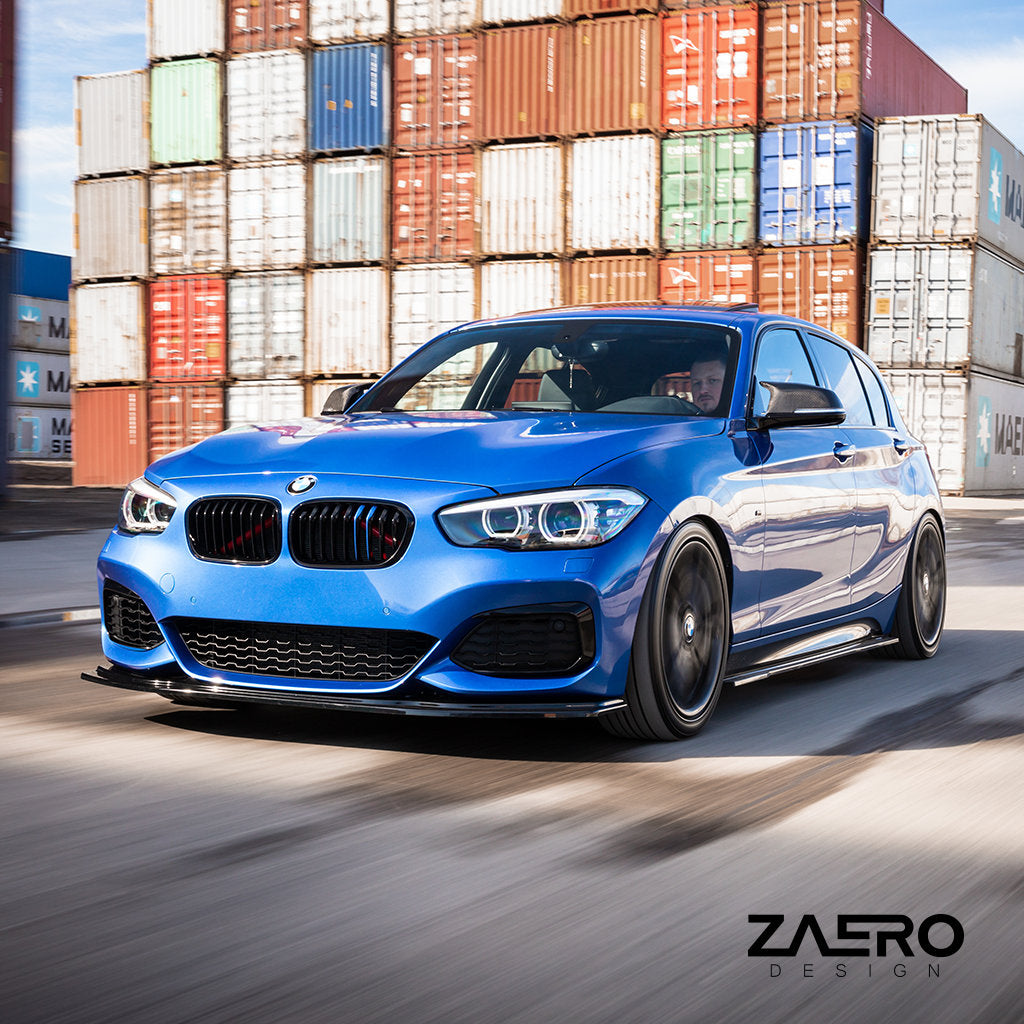 Ein blauer BMW F2x mit einem ZAERO Evo-1 Frontspoiler in Glanz Schwarz fährt an gestapelten Schiffscontainern vorbei, in der Ecke prangt das ZAERO-Logo.